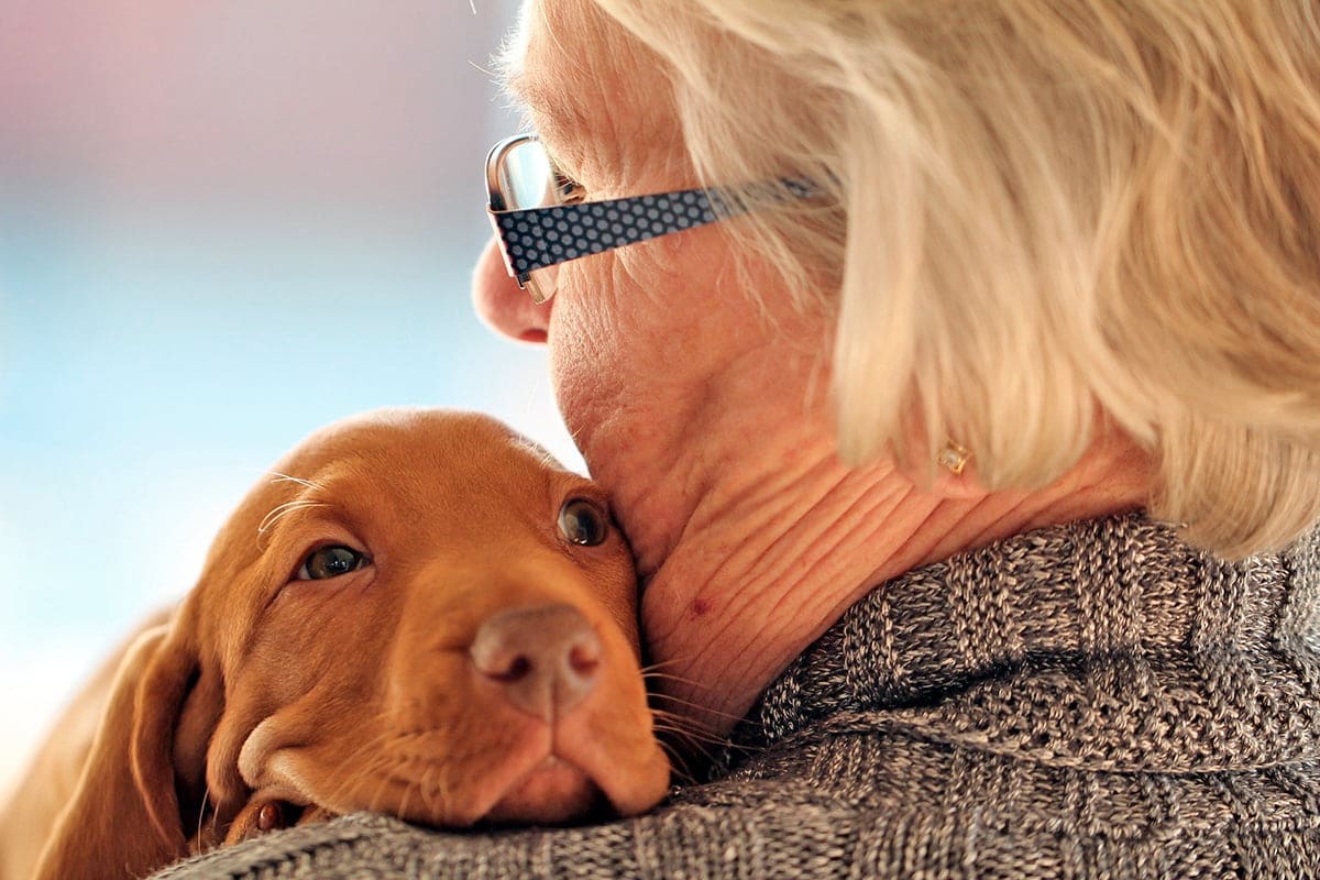 anciana abrazando a su perro